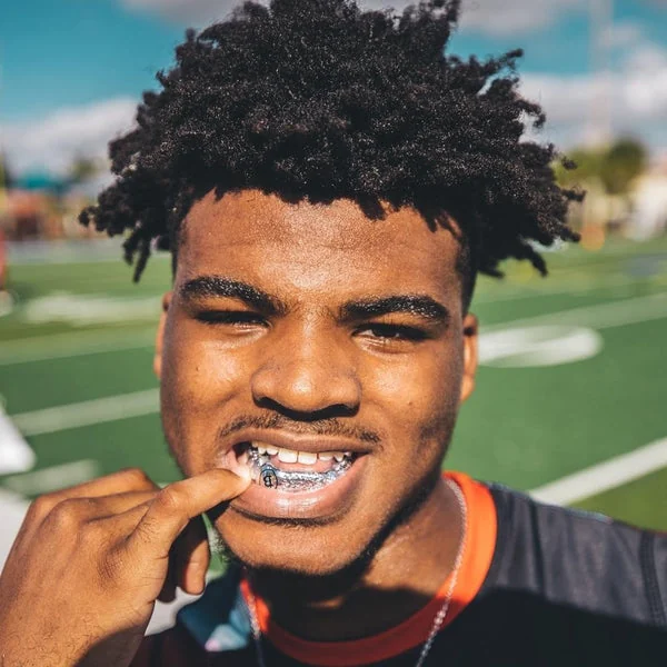 Athlete wearing a visible sports mouthguard on a field.